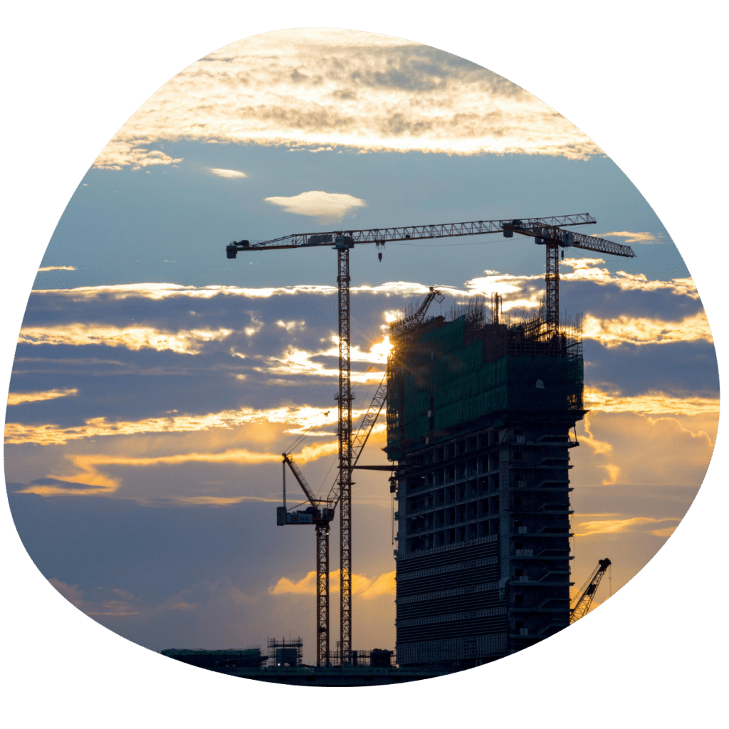 Grúas de construcción y un edificio en construcción en un atardecer - Aprender WordPress