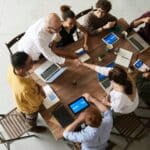 Personas trabajando juntas en una mesa.